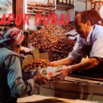 Shopkeeper handing a box of dates to a customer at a local market in Sonapur Dubai